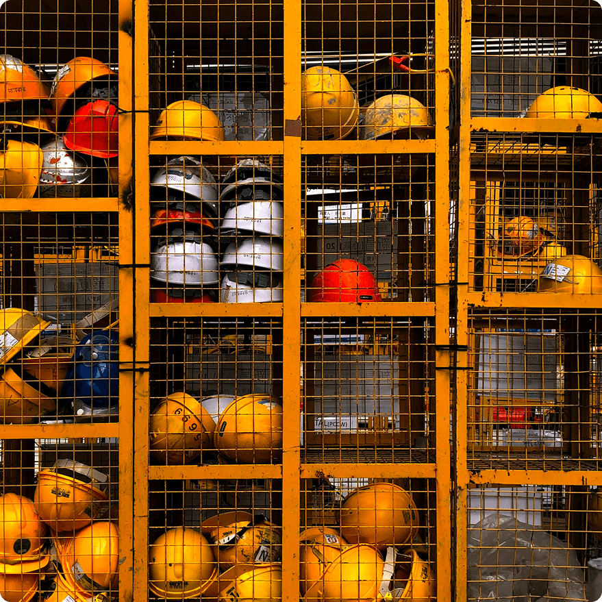 Hard hats stored in yellow industrial cages