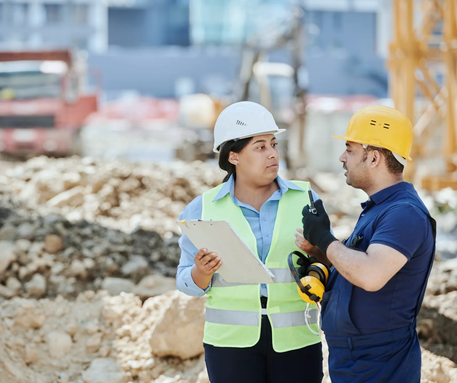 Site supervisor with a clipboard talking with a crew member on site