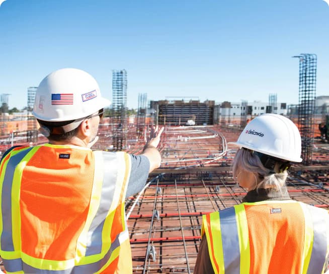 Construction workers reviewing site safety from a rooftop