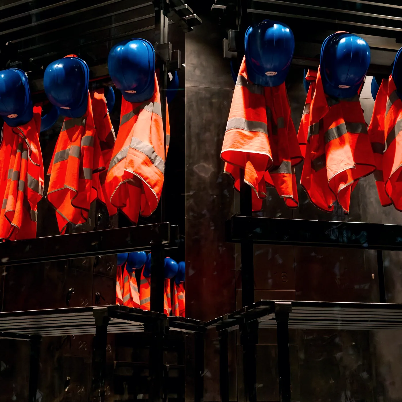 Hard hats and hi-vis vests ready at a PPE station
